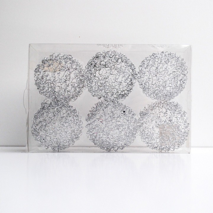 Six sphères transparentes ornées de motifs délicats et entrelacés, sur fond blanc.