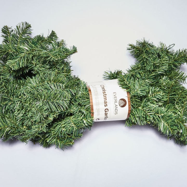 Guirlande de sapin artificiel, verte, enroulée avec un label en papier.