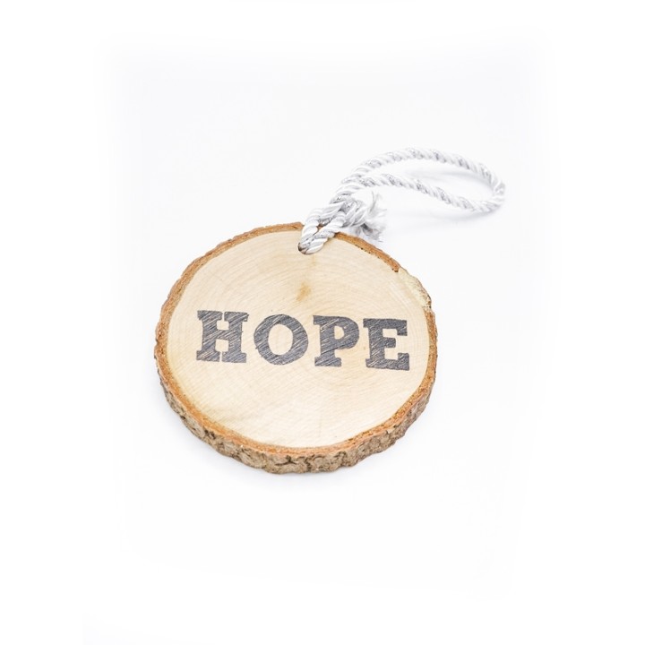 Disque en bois avec l'inscription "HOPE", cordon blanc, style naturel et minimaliste.