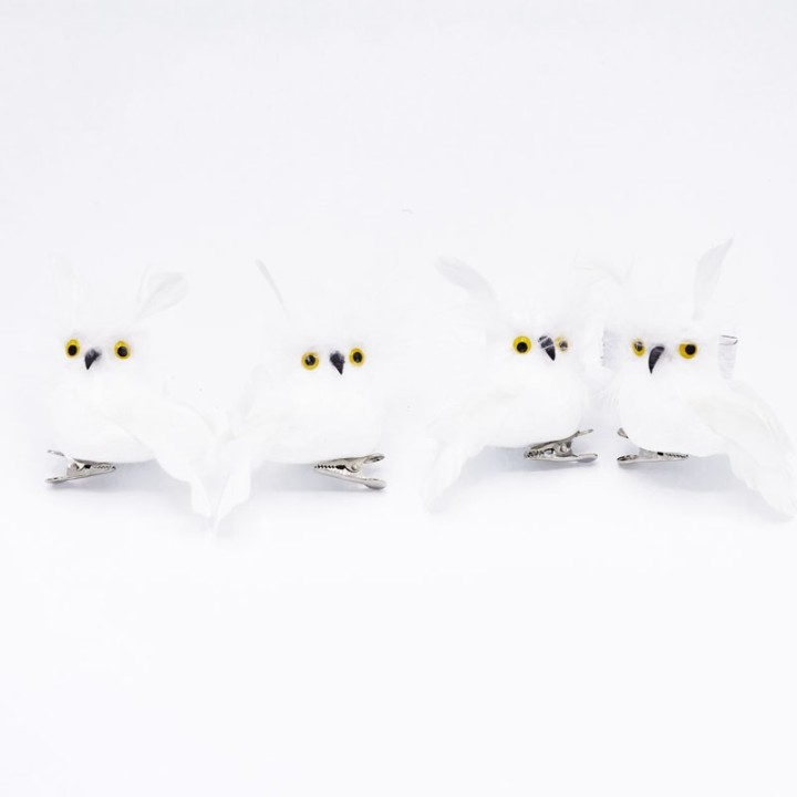 Quatre hiboux en plumes blanches aux yeux jaunes, fixés sur des pinces argentées.