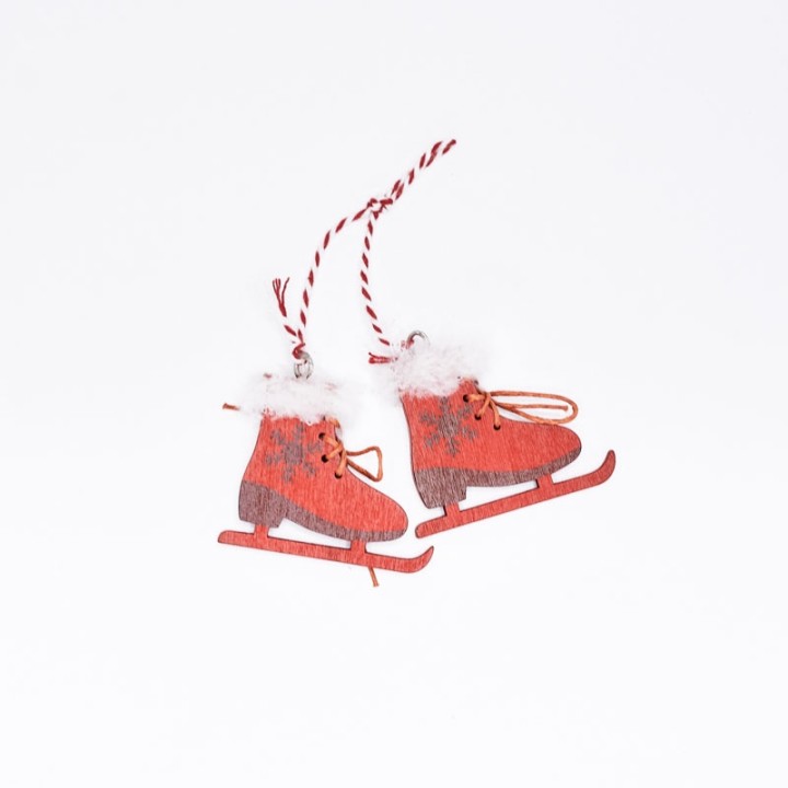 Patins de glace en bois rouge avec pompons blancs et corde à suspendre.