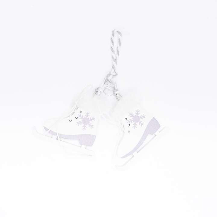 Patins à glace blancs ornés de flocons, suspendus par une cordelette grise.