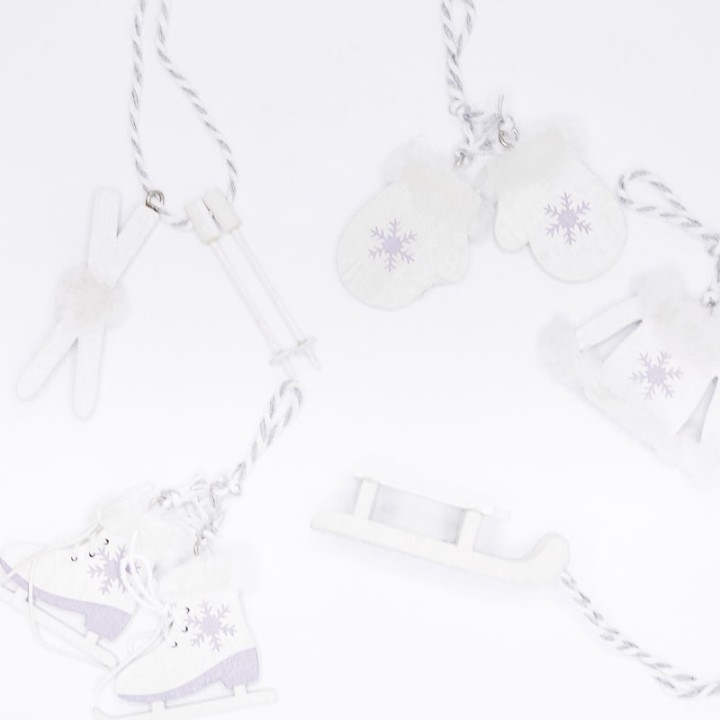 Décoration hivernale en blanc et violet avec patins, moufles et luge.
