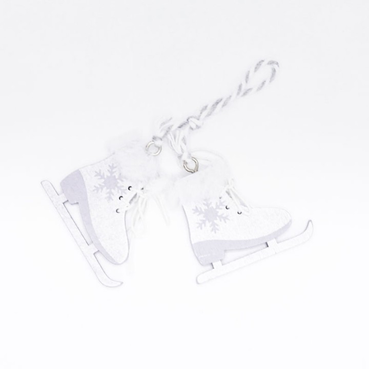 Patins à glace en papier blanc, ornés de flocons, suspendus par une corde tressée.