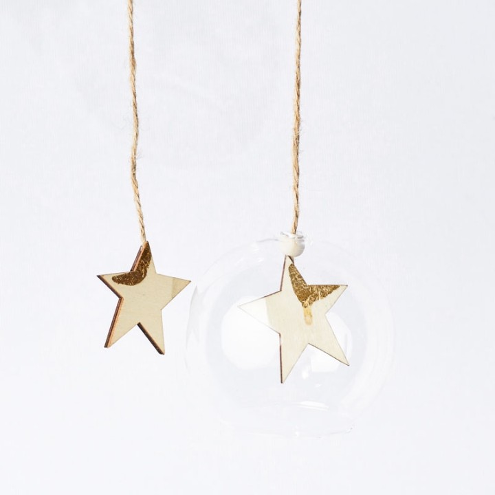 Étoiles dorées suspendues, brillantes, accompagnées d'une sphère transparente.