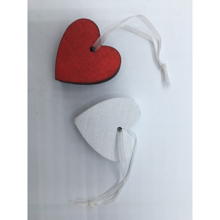 Cœurs en bois, l'un rouge brillant, l'autre blanc mat, suspendus par un fil transparent.