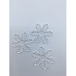 Flocons de neige en plastique transparent sur fond blanc, délicats et sculptés.