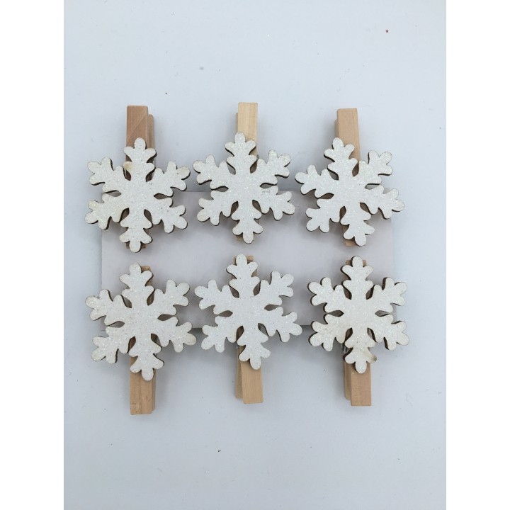 Pince à linge en bois ornée de flocons de neige blancs, style festif et naturel.