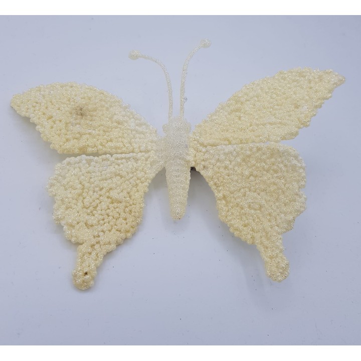 Papillon délicat en matériaux texturés, teinté de blanc crémeux.