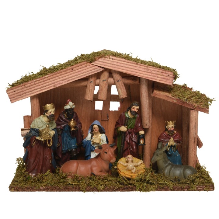 Crèche de Noël en bois avec figures colorées, mousse, et décor traditionnel.