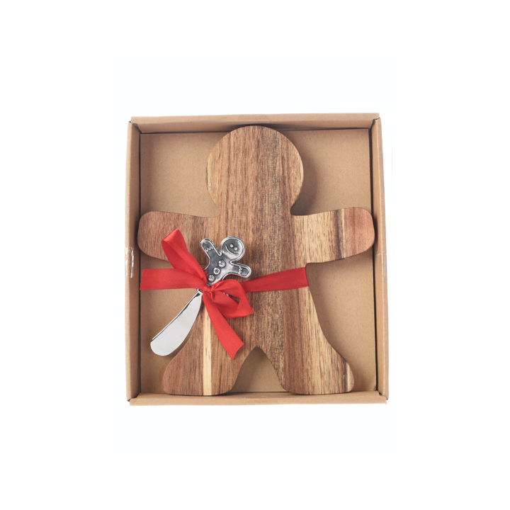 Planche en bois en forme de bonhomme, décorée d'un ruban rouge et d'une cuillère en métal.