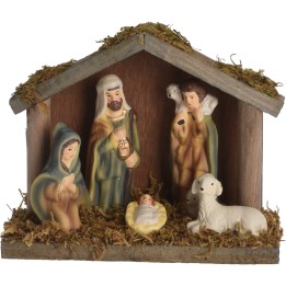Crèche de Noël en céramique, figurines colorées, toit en bois, ambiance chaleureuse.