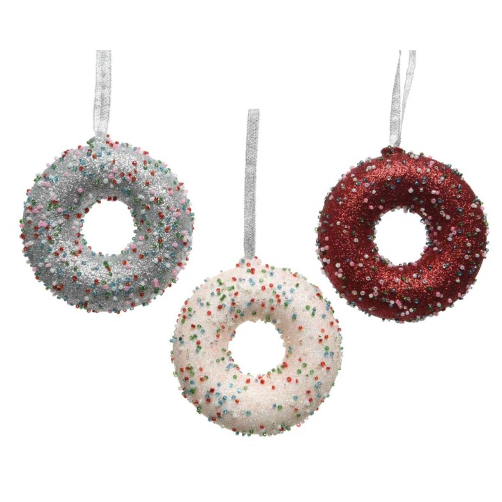 Trois donuts décoratifs aux paillettes, rouge, blanc et argent, suspendus par un ruban.
