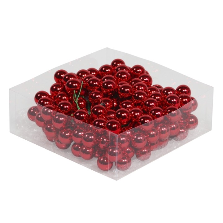 Boules rouges brillantes empilées dans une boîte transparente, créant une ambiance festive.