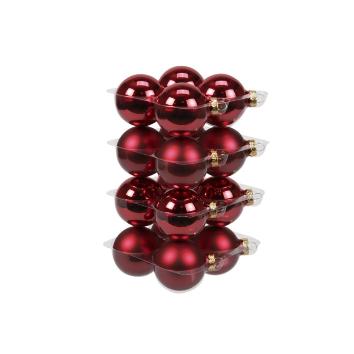 Boules de Noël rouges brillantes empilées dans un emballage transparent.