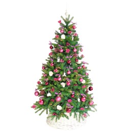 Sapin de Noël décoré de boules roses et blanches, sur panier tressé, ambiance festive.