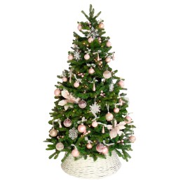 Sapin de Noël vert décoré de boules roses et de flocons, reposant dans un panier blanc.