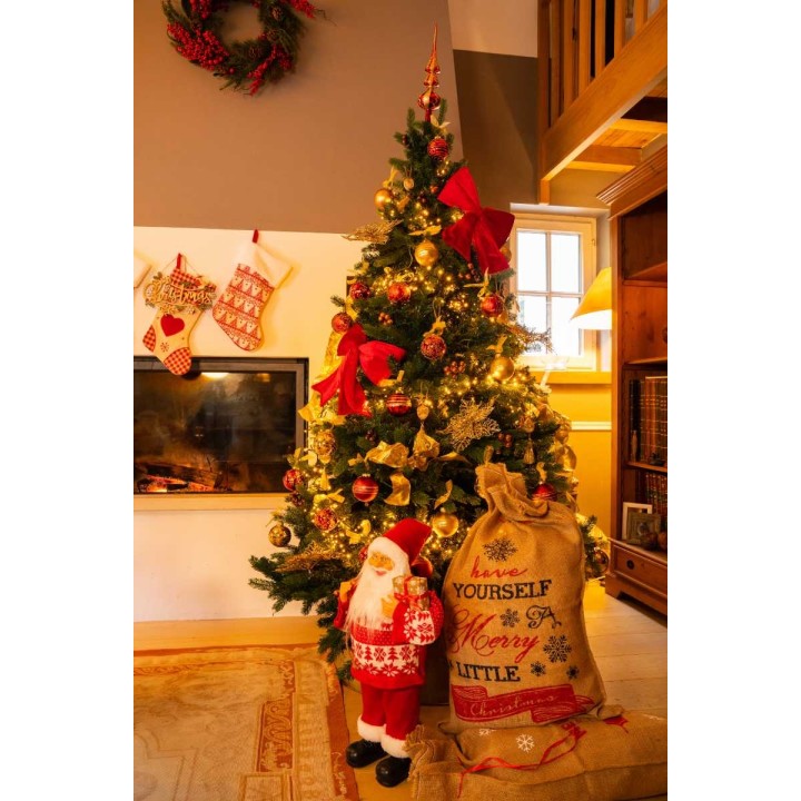 Un sapin festif décoré, avec un Père Noël en peluche et des cadeaux sous les lumières scinti...