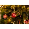 Boules de Noël rouges et dorées suspendues à un sapin lumineux, décorations festives. Boules de Noël rouges et dorées suspendues à un sapin lumineux, décorations festives.