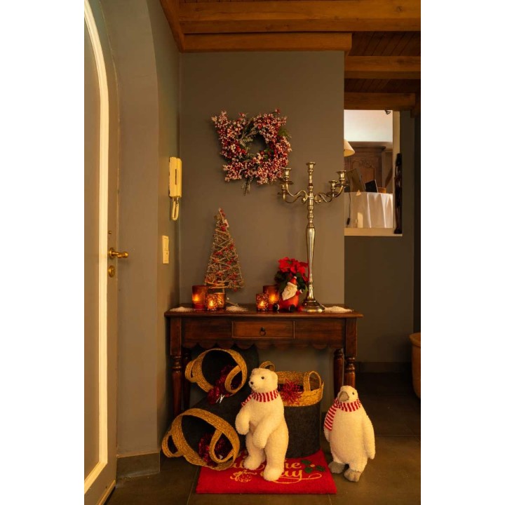 Entrée chaleureuse avec décorations festives, ours en peluche et ambiance lumineuse douce.