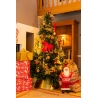 Sapin décoré de guirlandes dorées, cadeaux colorés, et un père Noël en tissu.