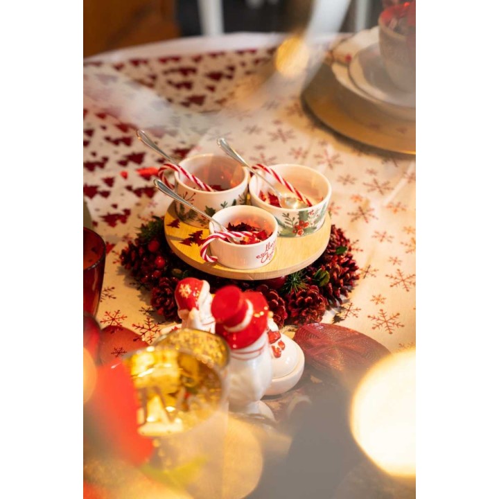Décor festif avec bols décorés, bonbons, et figurines sur une table ornée.
