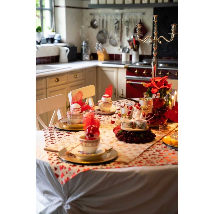 Table élégamment dressée avec vaisselle fine, décor rouge et doré, ambiance chaleureuse.