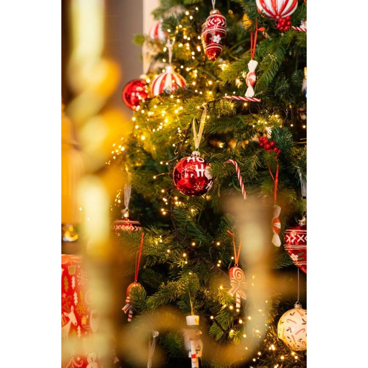 Sapin de Noël décoré de boules rouges et de guirlandes scintillantes.