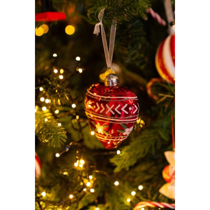 Boules de Noël rouges ornées de motifs, suspendues parmi des lumières scintillantes.
