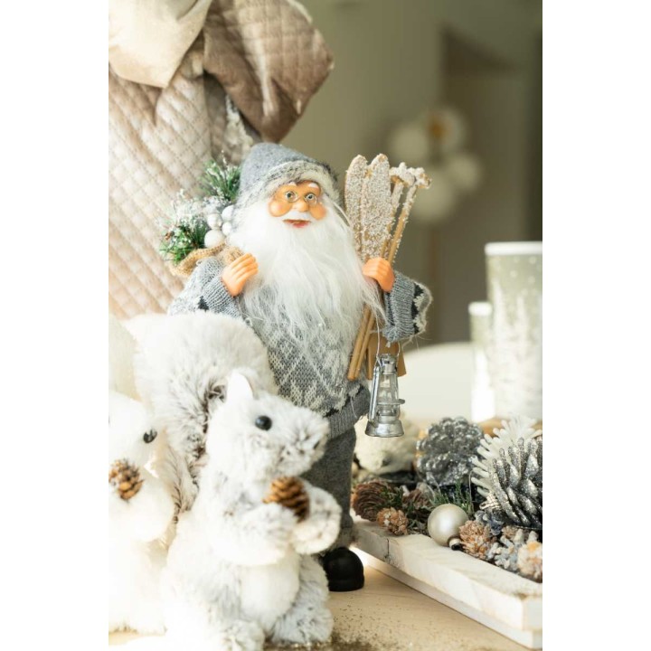 Un père Noël en peluche, entouré de petits écureuils et de décorations hivernales.