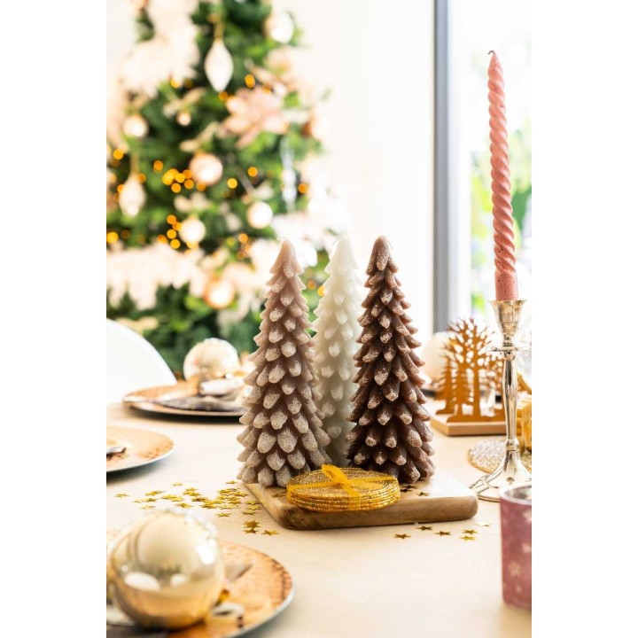 Trois sapins en bois pastel sur une table festive, illuminée de guirlandes dorées.