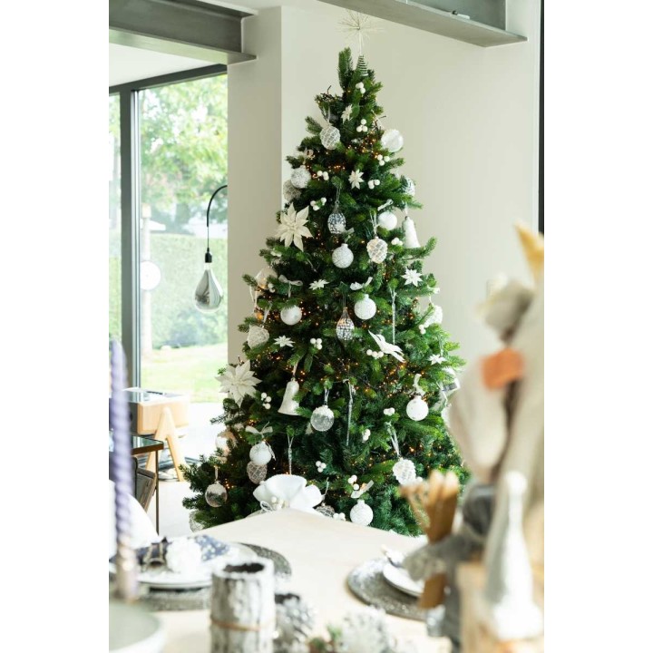 Sapin de Noël décoré de blanc et argent, illuminant un intérieur moderne et élégant.