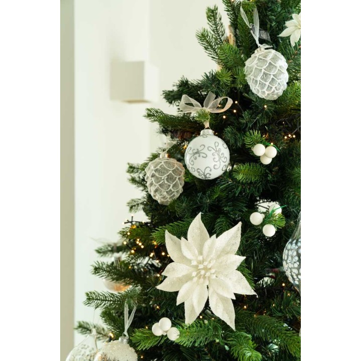 Ornements blancs et argentés embellissent un sapin, avec une étoile en fleurs délicates.