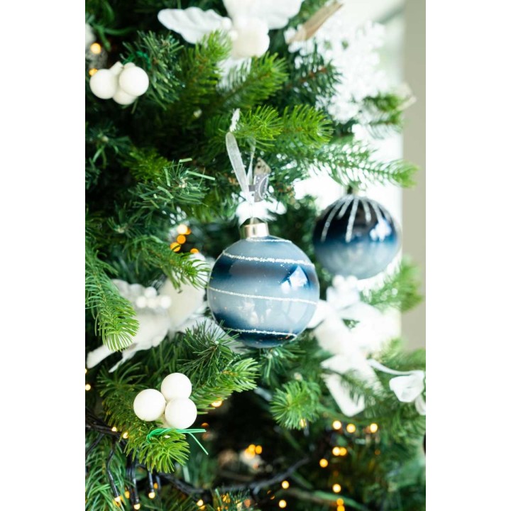 Boule de Noël bleue décorée, suspendue sur un sapin verdoyant, agrémentée de guirlandes blan...