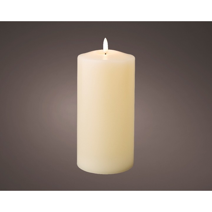 Bougie cylindrique crème, lueur douce sur fond sombre.