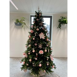 Sapin décoré de rose et blanc, ornements floraux et boules brillantes, ambiance chaleureuse.