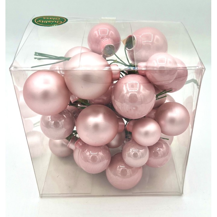 Boules décoratives roses en verre, brillantes, regroupées dans un emballage transparent.