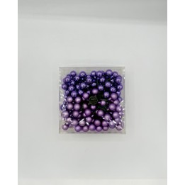Un assortiment de perles violettes, brillantes et mates, dans une boîte transparente.