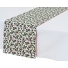 Nappe blanche avec chemin de table à motifs de houx rouges et verts sur fond clair.