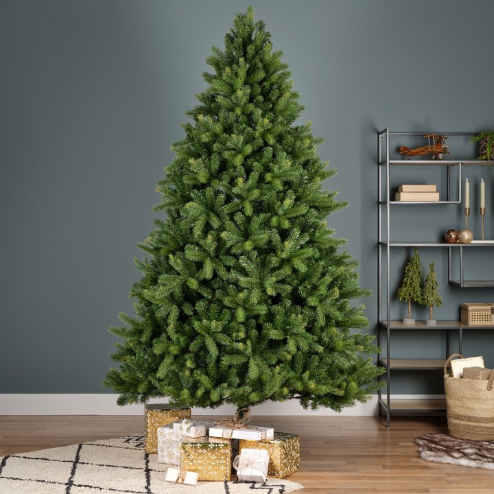 Sapin de Noël vert luxuriant entouré de cadeaux, décoré dans un intérieur moderne.