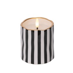 Bougie cylindrique avec rayures noires et blanches, bord doré, flamme dansante.