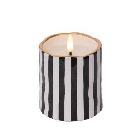 Bougie cylindrique avec rayures noires et blanches, bord doré, flamme dansante.