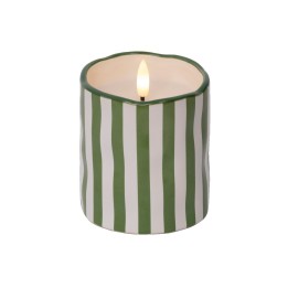 Bougie blanche et verte à rayures, flamme dans un contenant ondulé.