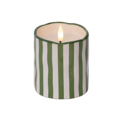 Bougie blanche et verte à rayures, flamme dans un contenant ondulé.