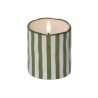 Bougie blanche et verte à rayures, flamme dans un contenant ondulé.