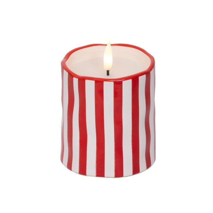 Bougie ronde aux rayures rouges et blanches, flamme vacillante au centre.
