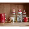 Mugs festifs et bocaux décorés sur une étagère en bois, illuminés par des guirlandes.