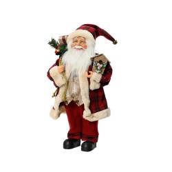 Père Noël souriant en costume rouge avec un chapeau, portant des cadeaux et un sapin.