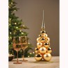 Arbre de Noël doré en boules, avec coupes élégantes sur une table festive.