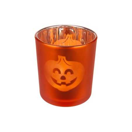 Bougie orange en verre avec un visage de citrouille souriant gravé.